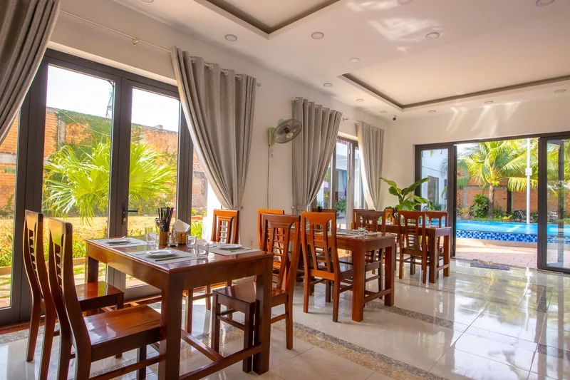 Dining area with wooden tables looking onto the pool