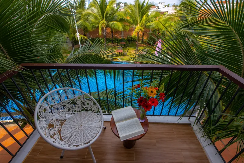 Balcony chair facing the pool and coconut palms