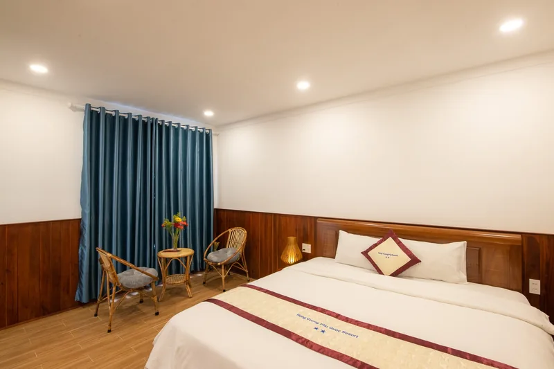 Wood-panelled Deluxe Pool View room with teal curtains