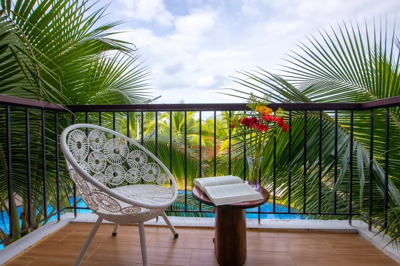 Balcony chair and pool below the palms