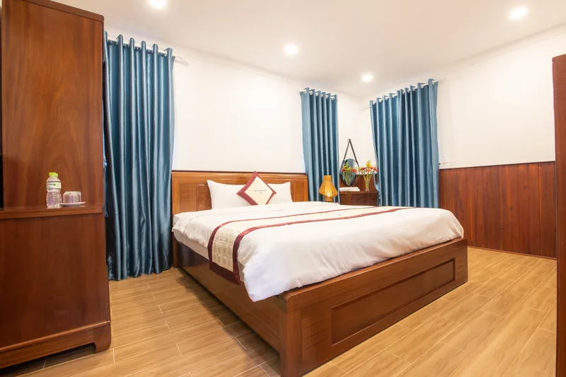 Double bed, wardrobe and blue curtains in a pool-view room
