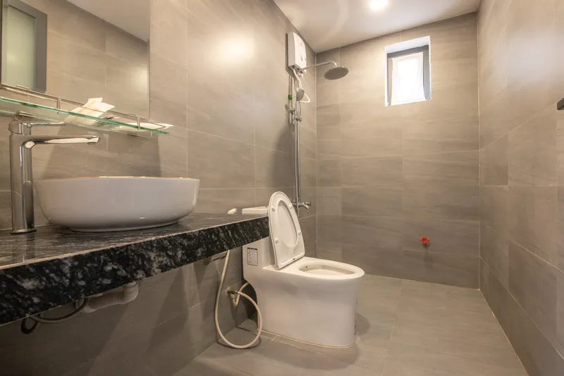 Bathroom with a granite counter and a rain shower