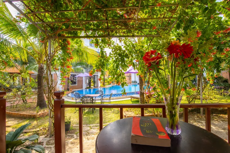 Bungalow terrace table under the vines with the pool in the background
