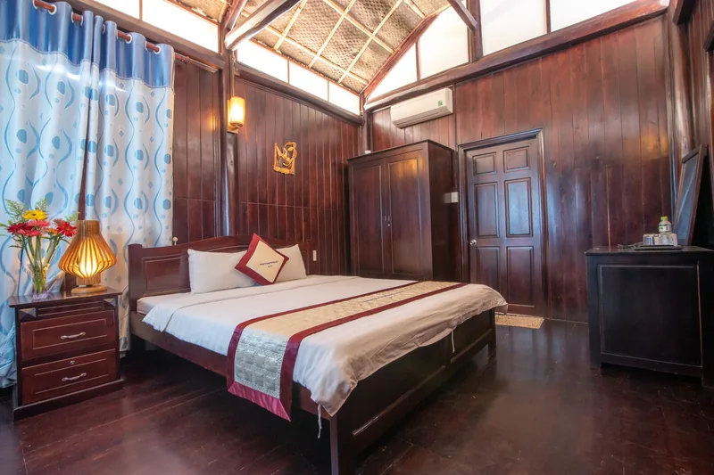 Double bed in a timber Pool View Bungalow with a skylight in the roof