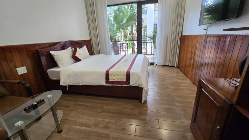 Timber-panelled Premium Garden View room with a double bed and TV