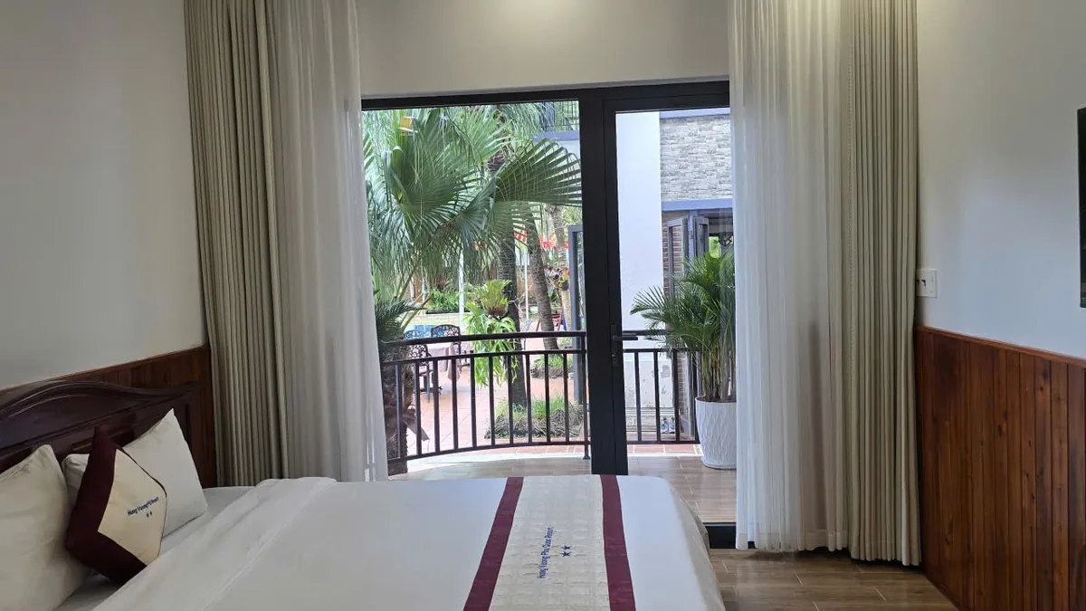 Premium Garden View room in the new wing with a balcony and palms outside