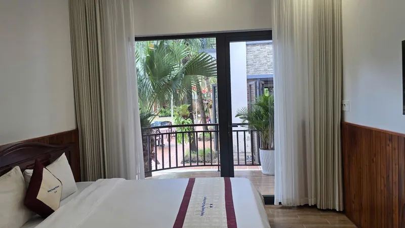 Premium Garden View room in the new wing with a balcony and palms outside