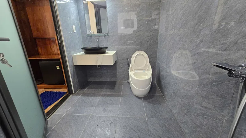 Bathroom with a black vessel basin and a modern toilet