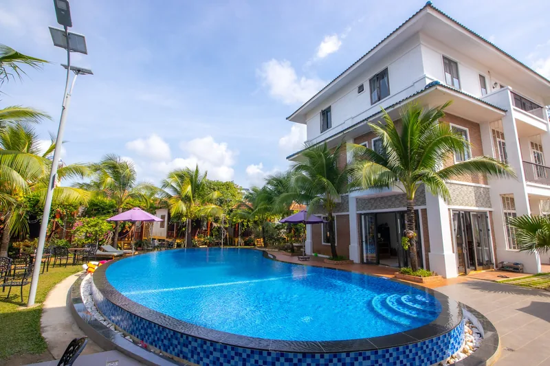 Pool and palms in front of the three-storey block at Hung Vuong Resort